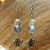 boucle d'oreille en labradorite et cristal de roche avec un papillon couleur argenté