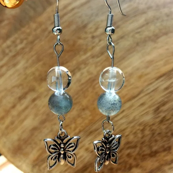 lame-agit-boucles-doreille-quartz-rose-cristal-de-roche-labradorite (2) boucle d'oreille en labradorite et cristal de roche avec un papillon couleur argenté